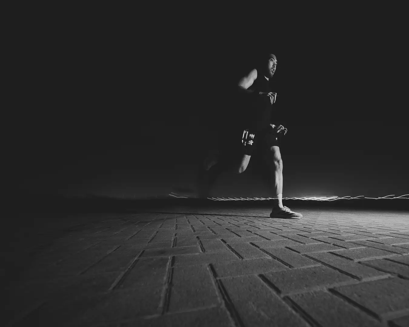 Athlete running on a lit path at night