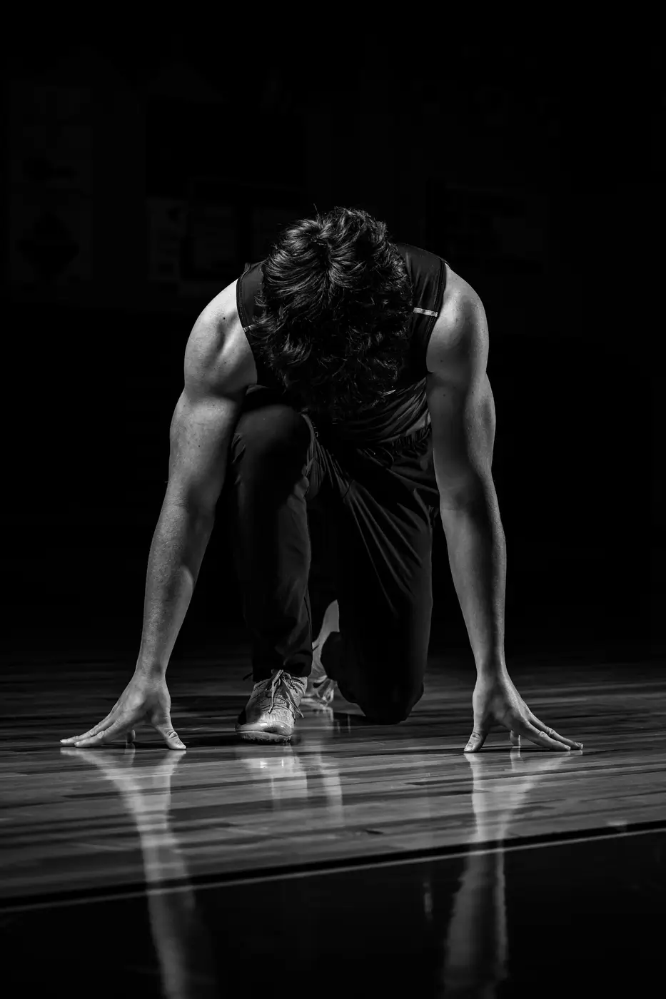 Sprinter set in the blocks under a spotlight
